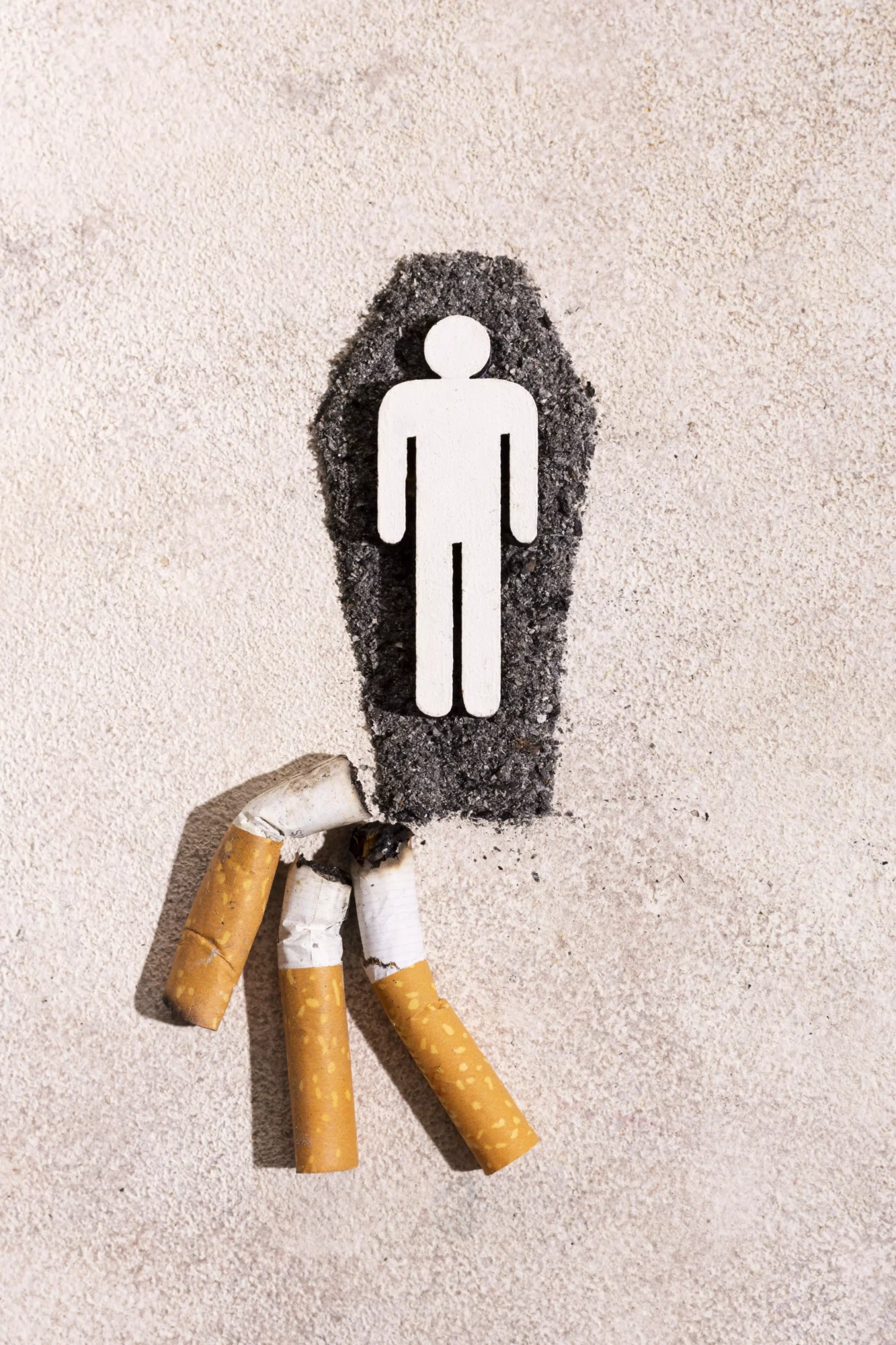 homme dans une tombe et des cigarettes écrasées